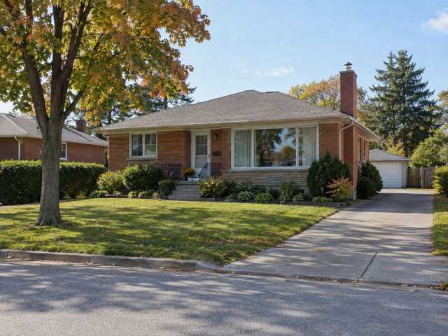 A 1950s brick bungalow with a picture window on a quiet Hamilton Mountain street